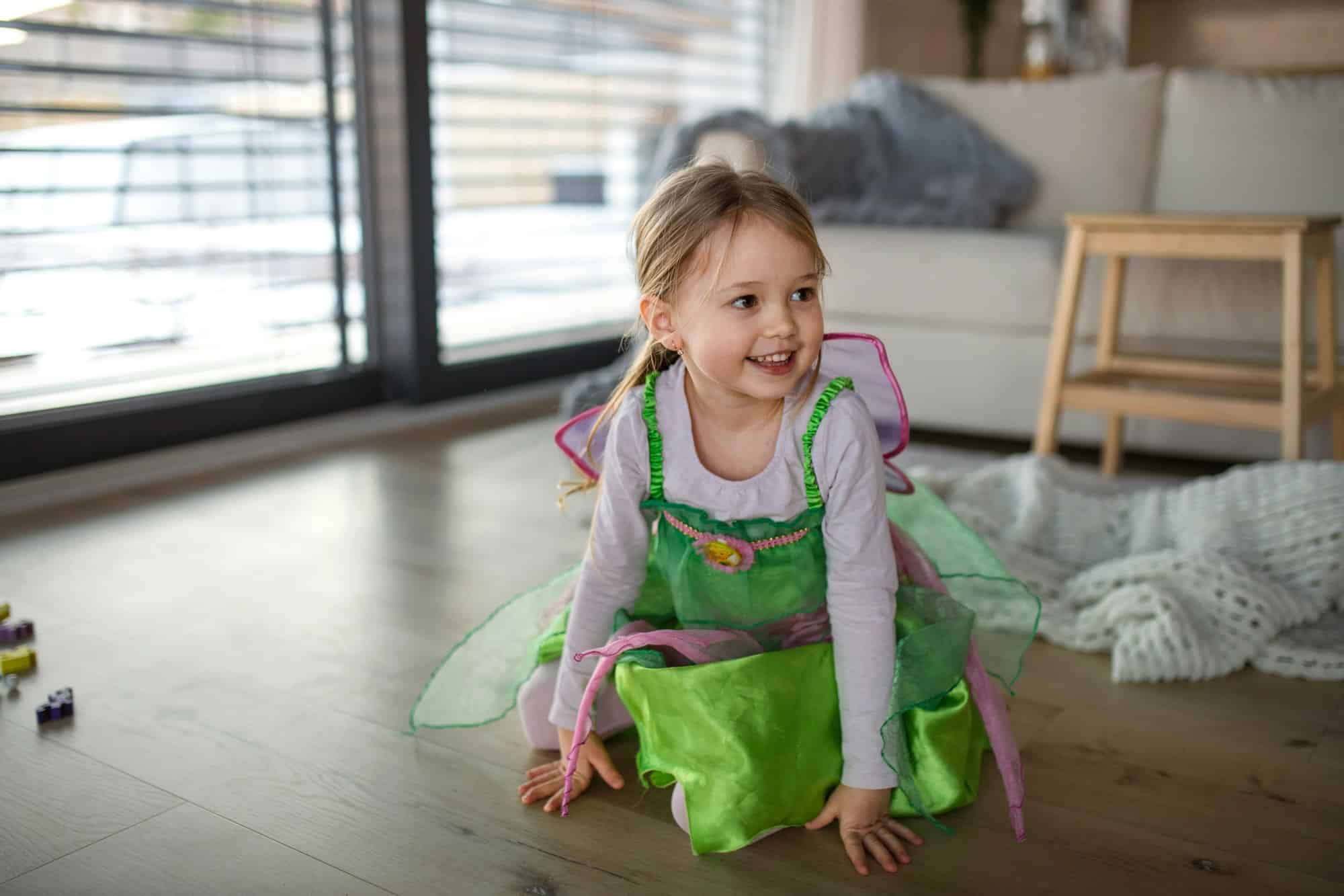 Little girl in fairy costume playing at home